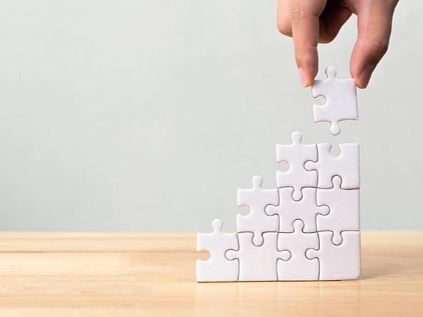 white jigsaw pieces being stacked up